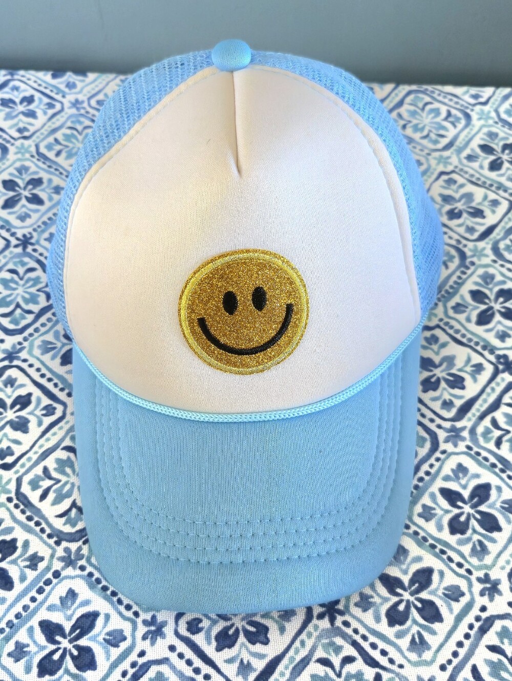 Light Blue Trucker Hat with Gold Smiley Patch